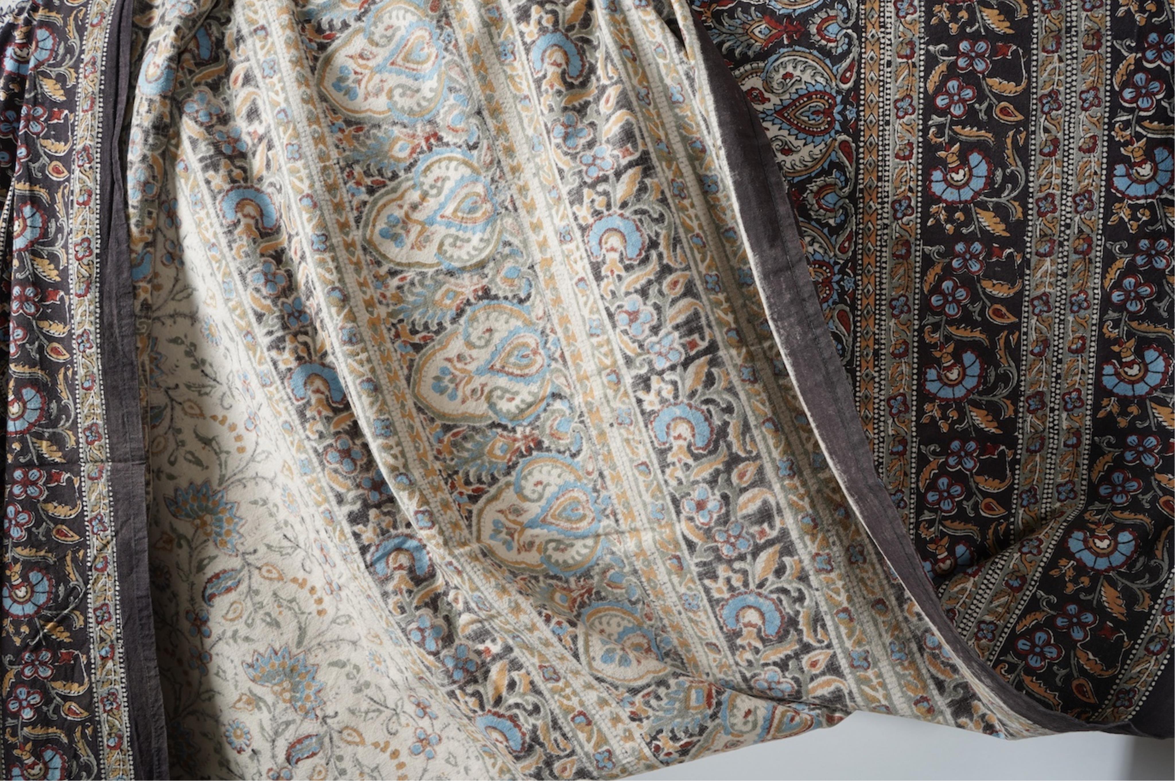 Two late 20th century large Indian block printed cotton bedcovers. One printed with brown borders, the other with brick red borders, both with large central panels designed in a classical Indian floral vining design. Bro
